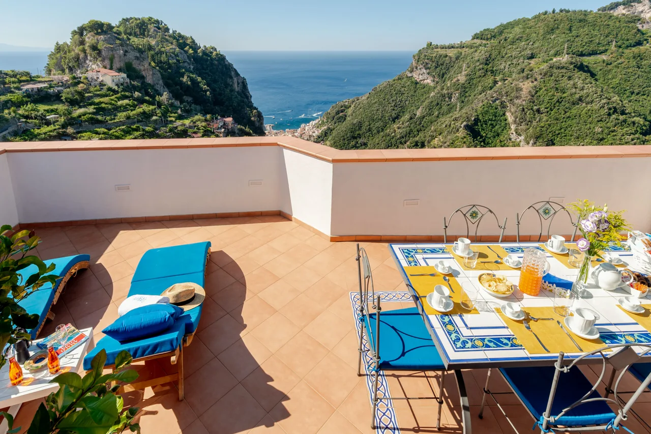 The private terrace of Suites 9: blue loungers, a ceramic table and sea views